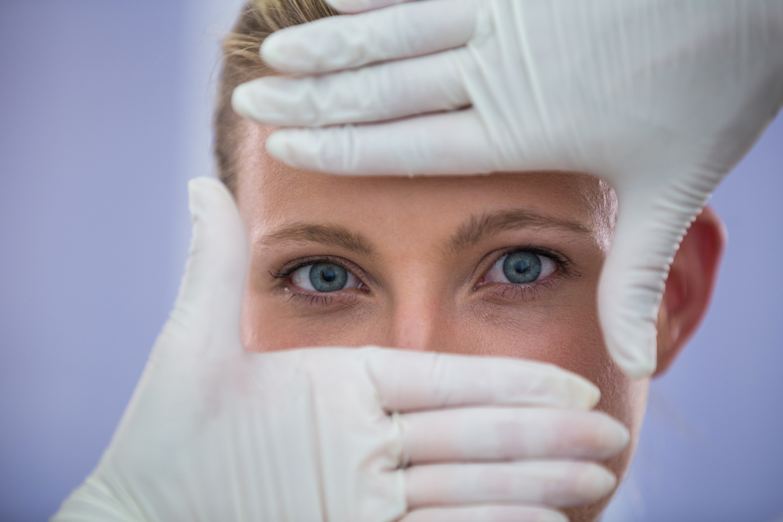 Patient après chirurgie oculaire - Mains sur le visage